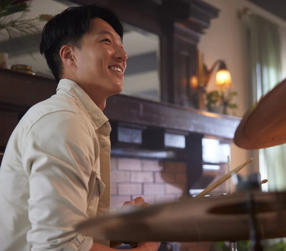 Man smiling playing drums